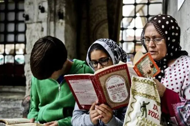 Senhora e jovem com véu islâmico leem em Istambul: governo conservador turco autorizou o uso do véu islâmico no ensino secundário (Ozan Kose/AFP)