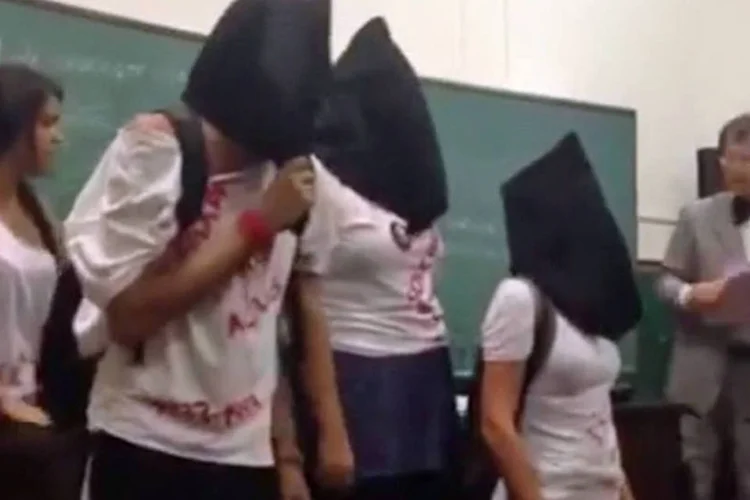 
	Alunos da USP invadem aula na Faculdade de Direito: encapuzados e cantando m&uacute;sicas s&iacute;mbolos da resist&ecirc;ncia &agrave; ditadura, eles protestaram contra discurso de professor
 (Reprodução/ Youtube)