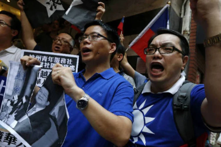 Manifestantes rasgam foto do presidente do Vietnã, Truong Tan Sang, durante protesto em frente ao consulado vietnamita em Hong Kong (REUTERS/Bobby Yip)