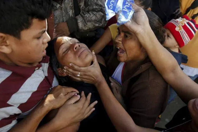 
	Pessoas ajudam familiar de v&iacute;tima de viol&ecirc;ncia em Honduras: novo ataque &eacute; a quarta chacina em uma semana no pa&iacute;s
 (REUTERS/Jorge Cabrera)