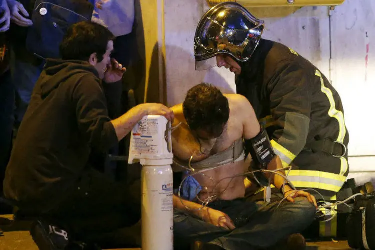 Vítima de ataque em Paris é socorrida por equipes de resgate. 13/11/2015 (Christian Hartmann/Reuters)