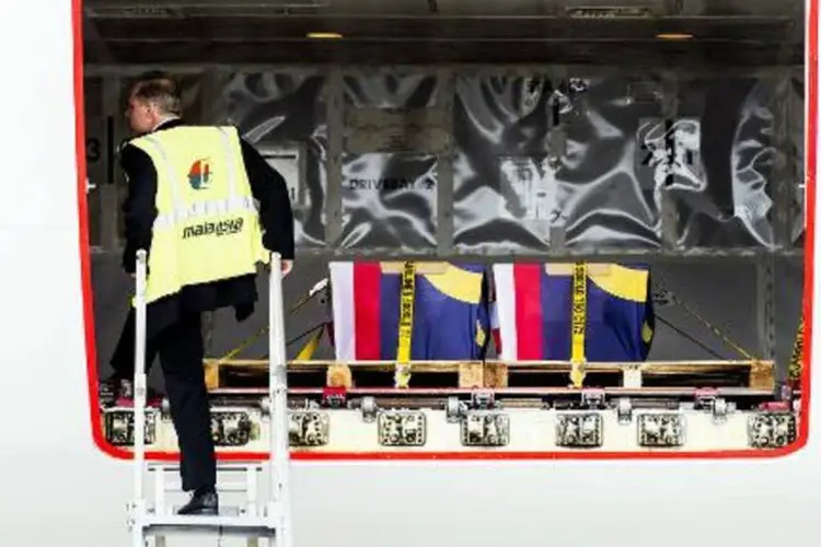 Funcionário organiza os restos mortais enviados para a Malásia, no Aeroporto Schiphol (Koen van Weel/AFP)
