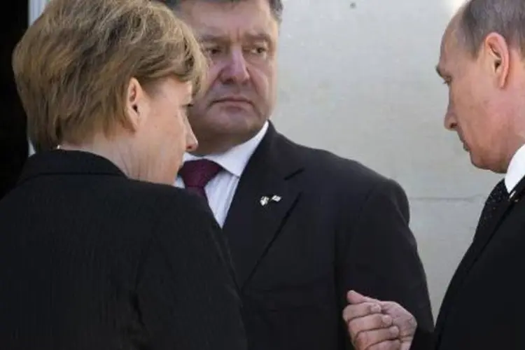 
	Merkel, Putin e Porochenko, presidente da Ucr&acirc;nia: prioridade deve ser evitar mais v&iacute;timas
 (Saul Loeb/AFP)
