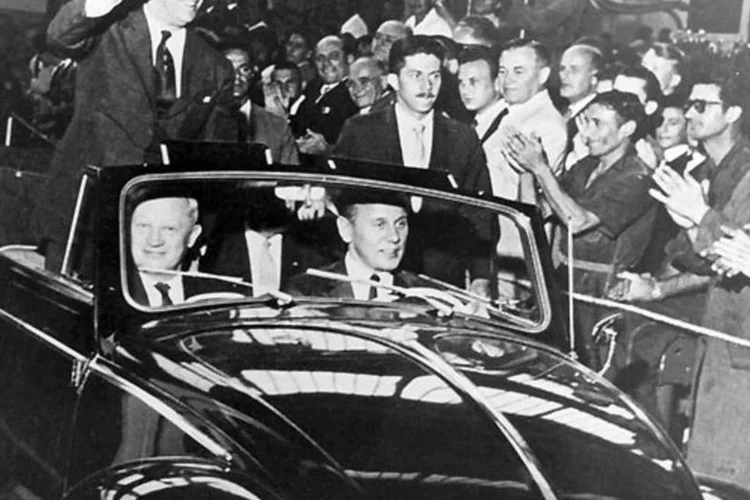 
	Juscelino Kubitschek acenando num Fusca convers&iacute;vel: vers&atilde;o oficial aponta que Kubitschek morreu em 22 de agosto de 1976 em acidente de carro na Via Dutra
 (Divulgação)