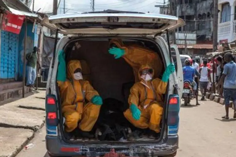 Voluntários saem para recolher corpos de vítimas do ebola, em Serra Leoa (Florian Plaucheur/AFP)