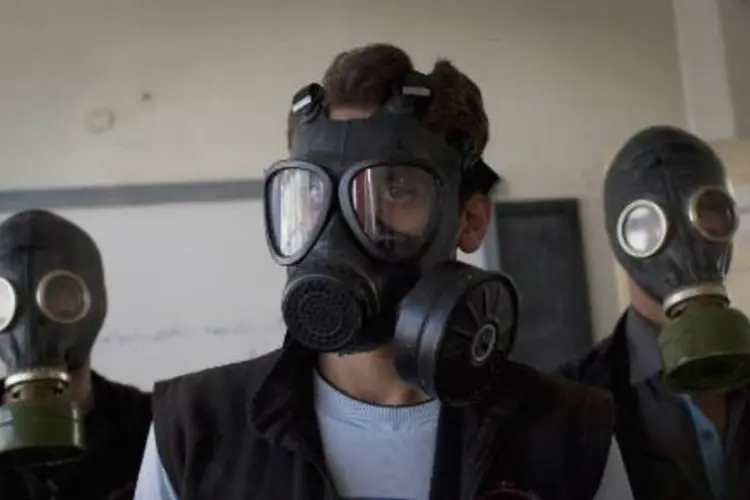 Voluntários com máscaras de gás durante uma aula sobre como agir a um ataque químico (Jm Lopez/AFP)