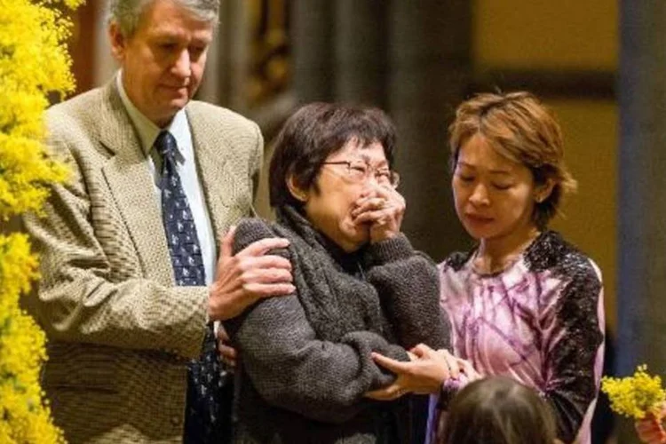 Uma família em luto por uma das vítimas do voo MH17, da Malaysia Airlines, na catedral de St. Patrick, em Melbourne (Mark Dadswell/AFP)