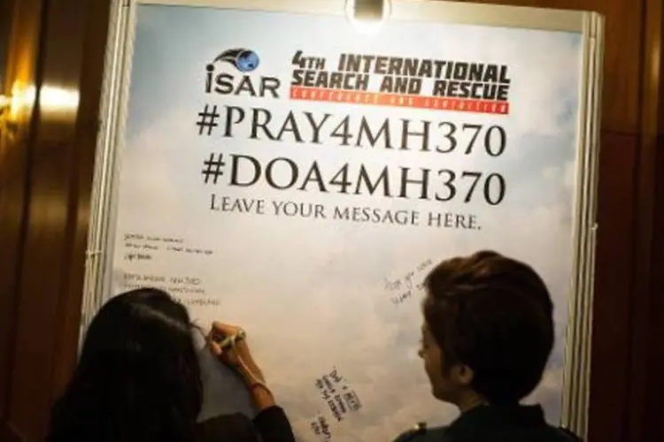 Participantes de conferência escrevem mensagens para passageiros do voo MH370 (Mohd Rasfan/AFP)