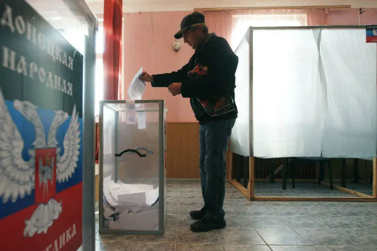 Homem deposita cédula de votação durante eleições na região separatista de Donetsk, Ucrânia (Maxim Zmeyev/Reuters)
