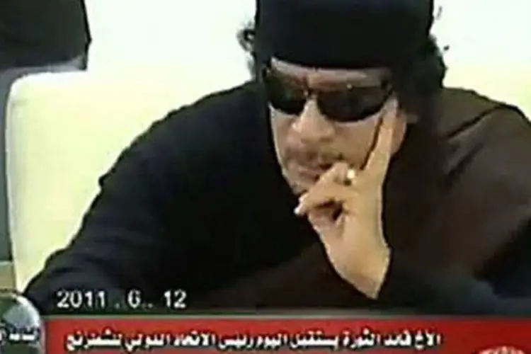 Muammar Kadafi usou óculos escuros durante a partida.
 (AFP)