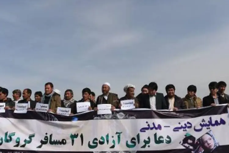 Parentes dos xiitas hazara sequestrados exibem cartaz durante protesto em cabul em 12 de março (Shah Marai/AFP)