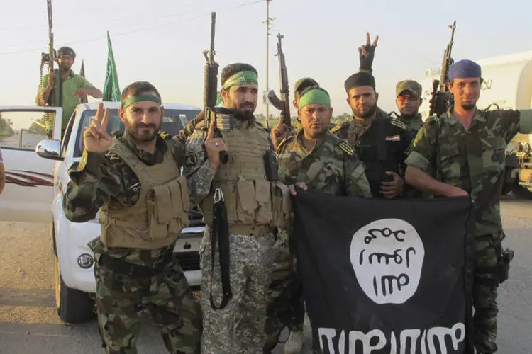 
	Xiitas com bandeira do Estado Isl&acirc;mico: EI proclamou no final de junho um califado no Iraque e S&iacute;ria, onde tomou partes do norte e do centro de ambos pa&iacute;ses
 (Stringer/Reuters)