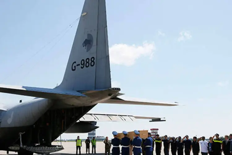 Guardas carregam caixão de uma das vítimas do voo MH17 até avião, que levará corpos à Holanda  (REUTERS/Gleb Garanich)