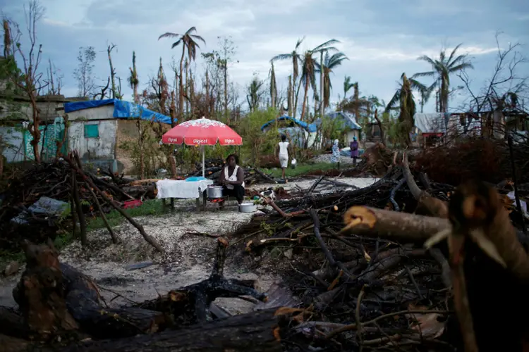 Vendedor haitiano após a passagem do furacão Matthew: apesar do aumento dos gastos, número de mortes por desastres naturais diminuiu em 2016 (Carlos Garcia Rawlins/Reuters)