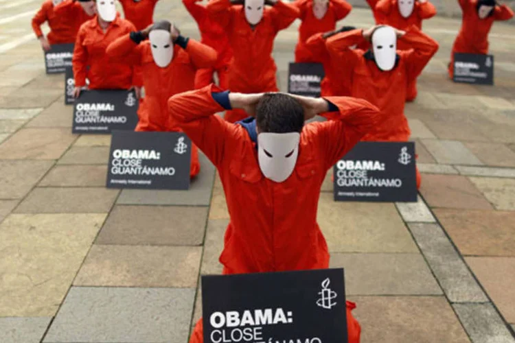 Ativistas da Anistia Internacional se vestem como prisioneiros de Guantánamo para pedir fechamento da prisão, em Belfast, em 16 de junho de 2013 (Cathal McNaughton / Reuters)