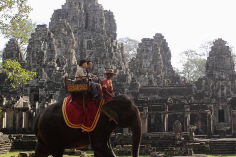 
	Turista anda de elefante nas ru&iacute;nas do Camboja
 (Erik De Castro/Reuters)