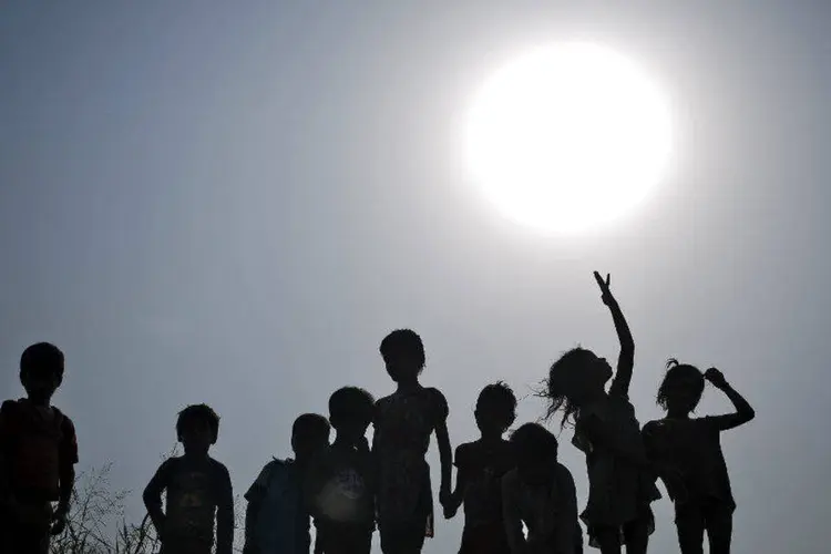 Silhueta de crianças debaixo de Sol forte em Nova Deli (Anindito Mukherjee/Reuters)