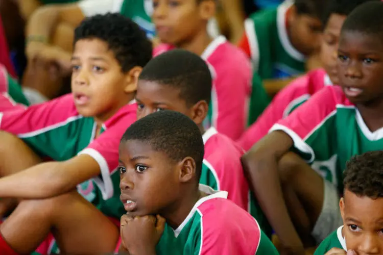 Crianças observam seleção feminina de futebol da Nova Zelândia durante visita a comunidade por causa da Olimpíada 2016 (Phil Walter/Getty Images)
