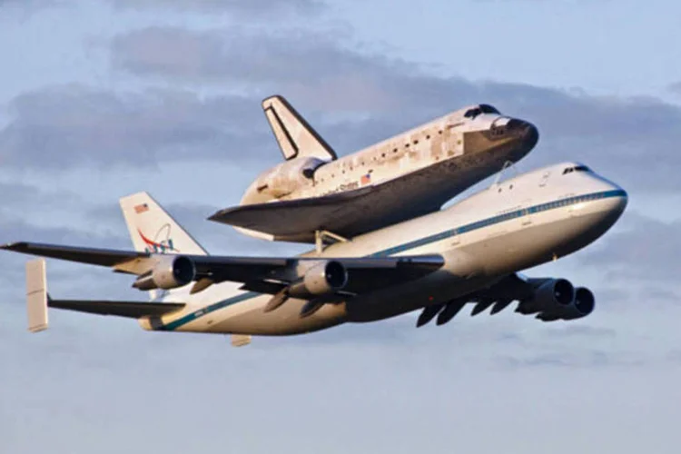 Ônibus espacial voa preso a um Boeing 747 adaptado em direção ao novo lar, um museu localizado no estado de Virginia (NASA/Jim Grossmann)