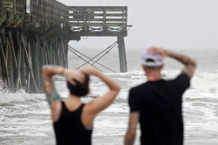 
	Pessoas observam ondas forte perto a pier durante passagem do furac&atilde;o Matthew nos EUA
 (Jonathan Drake / Reuters)