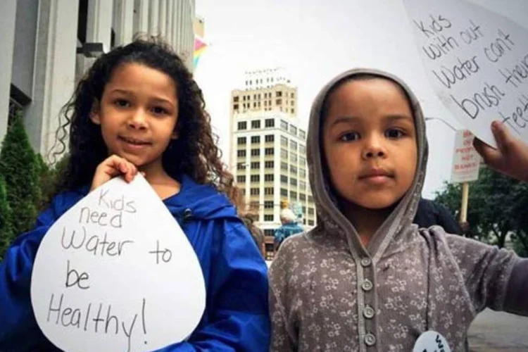 Crianças seguram cartazes em protesto contra cortes de água (Detroit Water Brigade)