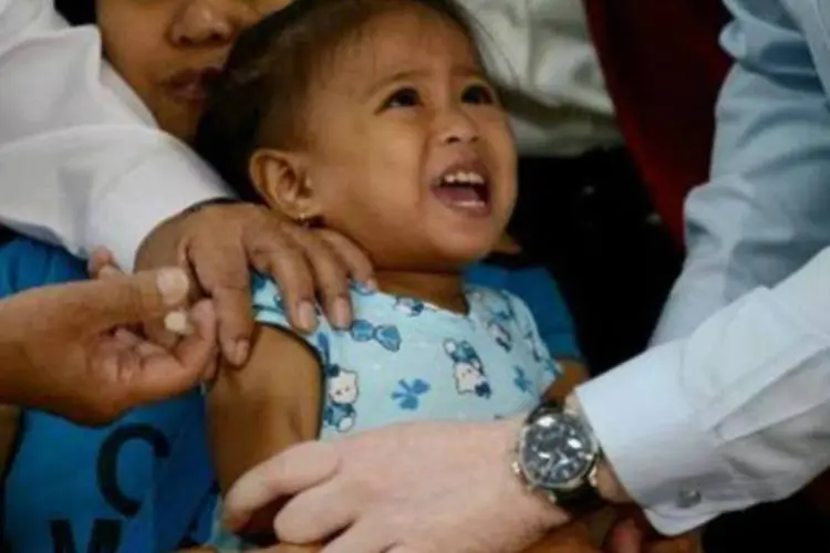 
	Crian&ccedil;a sendo vacinada: o resultado, segundo a Opas, culmina um esfor&ccedil;o de 22 anos de ampla administra&ccedil;&atilde;o da vacina contra o sarampo, a caxumba e a rub&eacute;ola no continente
 (AFP/Arquivos)