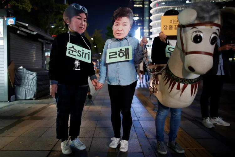 Manifestantes usam máscaras de Choi Soon-il e da presidente Park Geun-Hye (Kim Hong-Ji/Reuters)