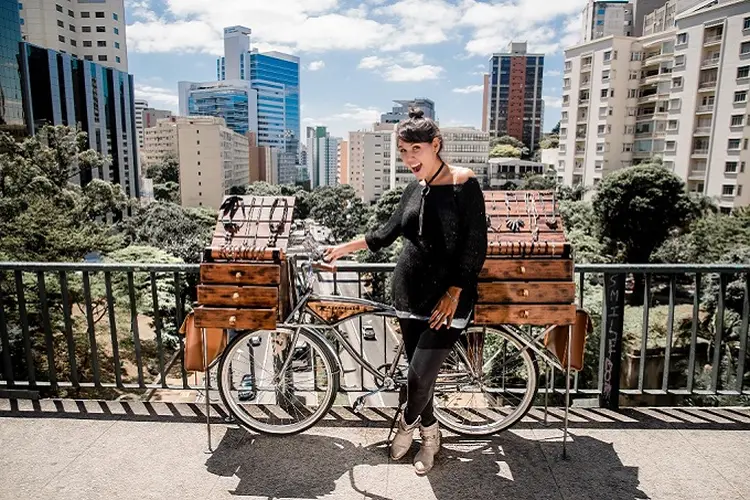 A empreendedora Flávia Ferreira com a bike de sua marca de acessórios (Divulgação)