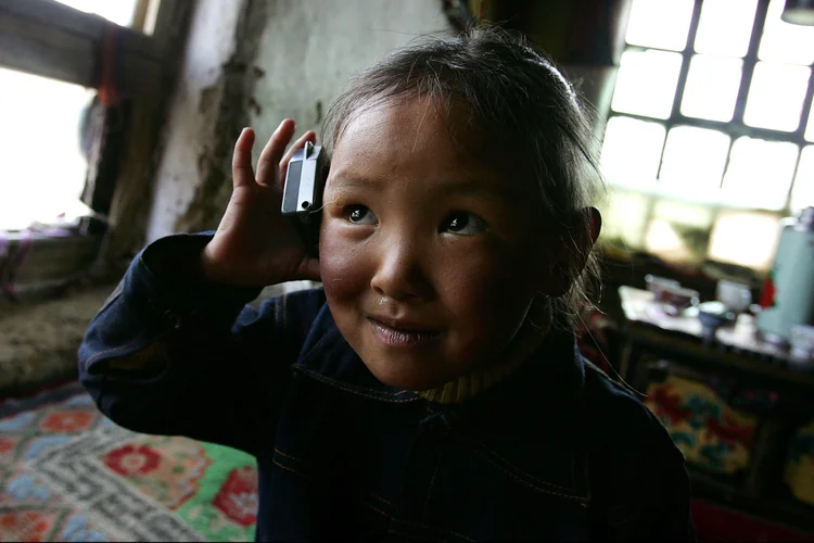 Criança chinesa ouve rádio em uma casa em pequeno vilarejo em Lhasa, na China  (Guang Niu/Getty Images)