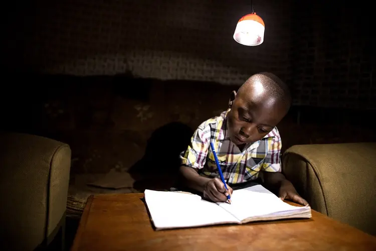 Com eletricidade: criança da África Subsaariana estuda com a lâmpada da GravityLight (GravityLight/Divulgação)