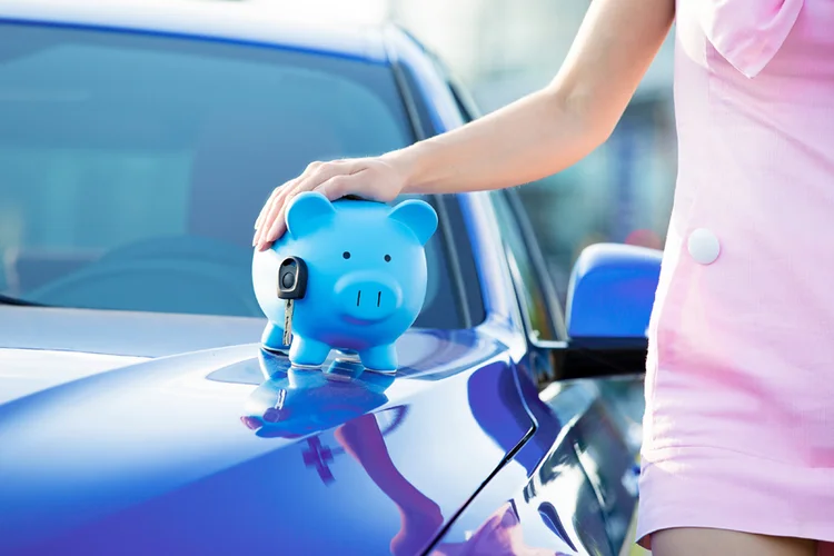 Cropped image woman customer, agent and new car, piggy bank, key on hood, isolated outside, outdoors. Dealership offering credit line, finance services. Lease, automobile purchase, financing concept (SIphotography/Thinkstock)