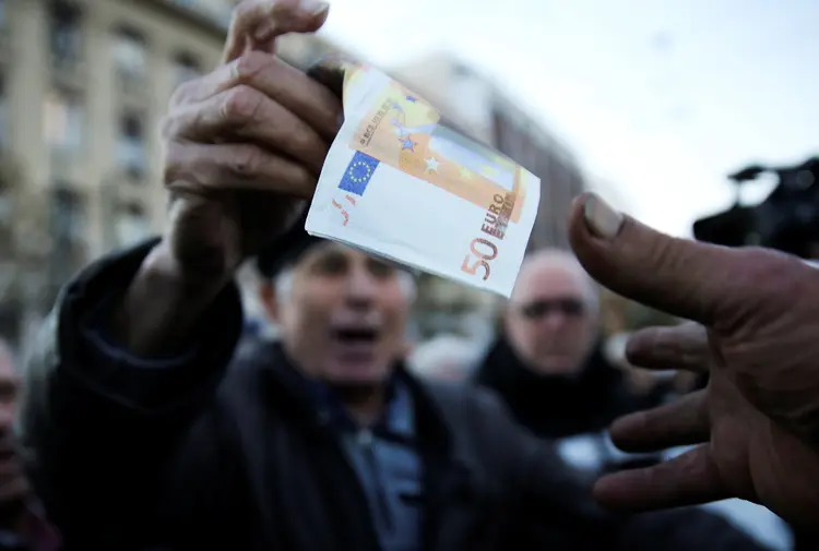 A Greek pensioner hands over a fake euro banknote during a demonstration against government policies affecting pensioners in Athens, Greece, December 15, 2016.  REUTERS/Alkis Konstantinidis (Alkis Konstantinidis/Reuters)