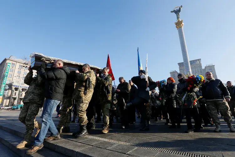Soldados ucranianos carregam corpo de companheiro morto em conflito com separatistas pró-Rússia (Valentyn Ogirenko/Reuters)