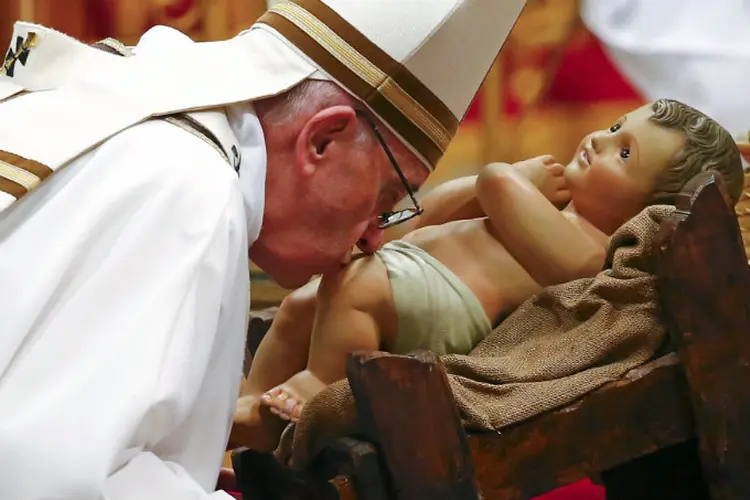 Papa Francisco beija uma estátua do menino Jesus no final da missa de Natal, no Vaticano (Tony Gentile/Reuters)