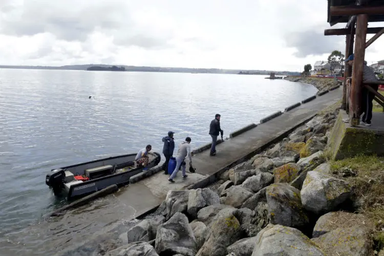 Habitantes locais descem de bote durante um alerta de tsunami na ilha de Chiloé, no Chile (Nicolas Klein/Reuters)