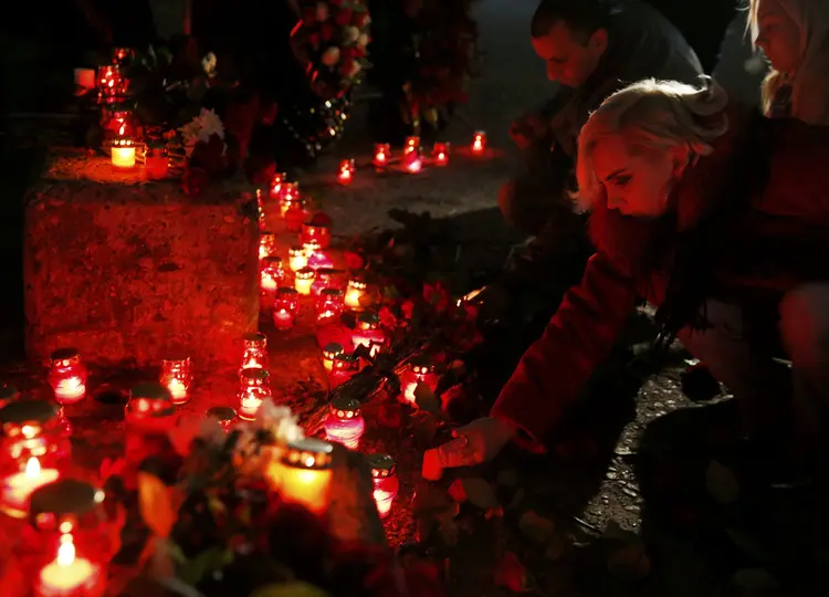 Pessoas homenageiam os mortos no acidente com o avião militar russo (Maxim Shemetov/Reuters)