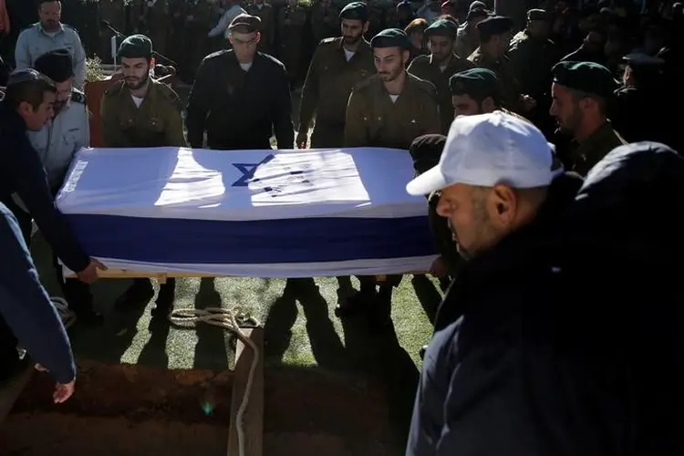 Israel: o caixão da tenente Shir Hadjaj, coberto com a bandeira de Israel, foi baixado em meio ao choro de familiare (Ronen Zvulun/Reuters)