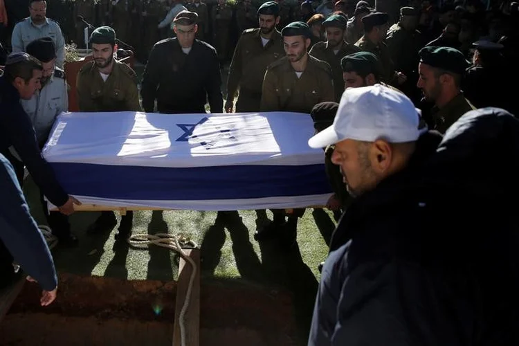 Israel: o caixão da tenente Shir Hadjaj, coberto com a bandeira de Israel, foi baixado em meio ao choro de familiare (Ronen Zvulun/Reuters)
