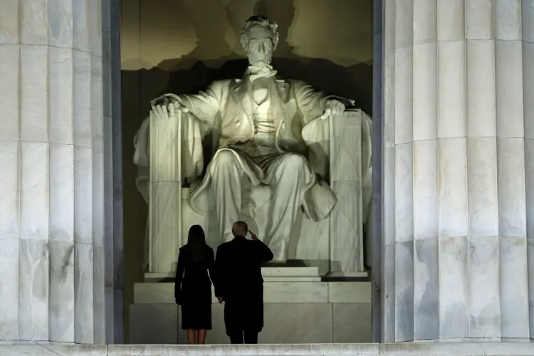 Donald e Melania Trump saúdam a estátua de Abraham Lincoln na chegada a um evento em Washington, antes da posse (Jonathan Ernst/Reuters)