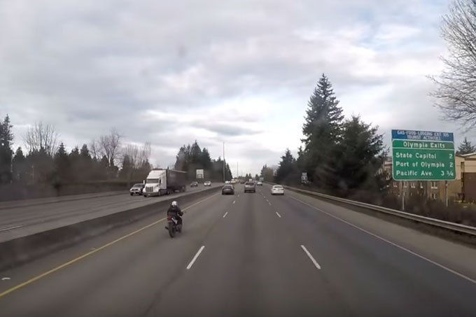 Motociclista bate e cai sentado na traseira de carro em movimento