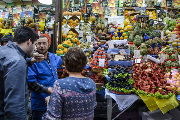 Feirante e consumidores no Mercado Municipal em São Paulo (Paulo Fridman/Bloomberg)