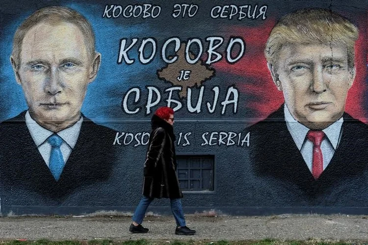Mulher passa em frente a mural com a imagem do presidente russo, Vladimir Putin, e do presidente dos EUA, Donald Trump, em Belgrado, na Sérvia. 04/12/2016. (Marko Djurica/Reuters)