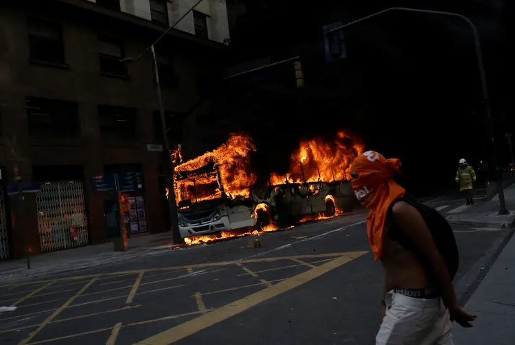 Rio: os manifestantes mascarados atearam fogo ao banco do motorista (Ricardo Moraes/Reuters)