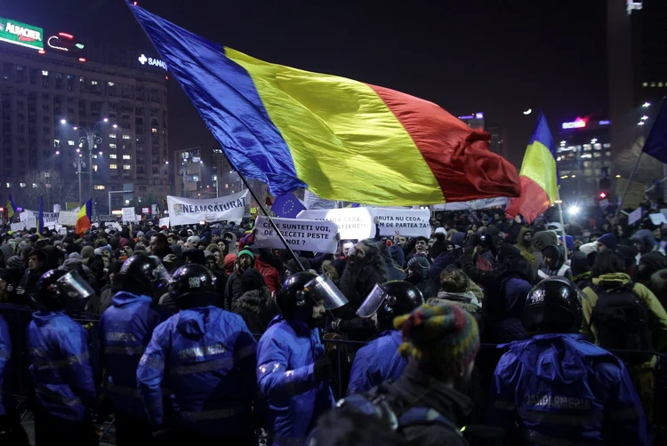 Manifestantes seguram bandeira da Romênia durante protesto contra descriminalização da corrupção (Inquam Photos/Octav Ganea/Reuters)