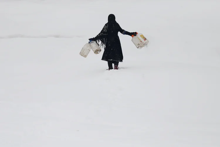 Garota afegã carrega garrafas de água após tempestade de neve que atingiu Cabul, no Afeganistão, em 05/02/2017 (Mohammad Ismail/Reuters)
