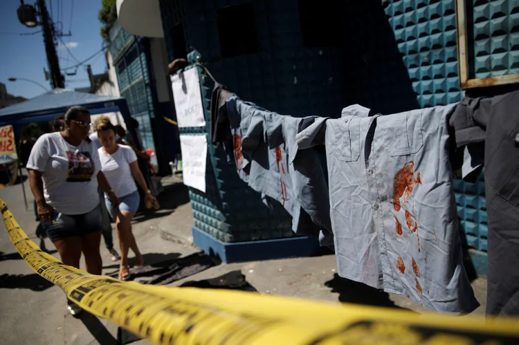 Uniformes da Polícia Militar manchados de vermelho em protesto de familiares na frente do 16º batalhão do Rio de Janeiro (Ricardo Moraes/Reuters)