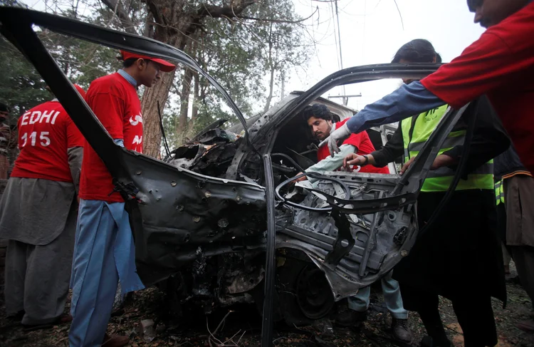 Voluntários removem veículo de local após atentado suicida no judiciário do Paquistão, em Peshawar, no dia 15/02/2017 (Fayaz Aziz/Reuters)