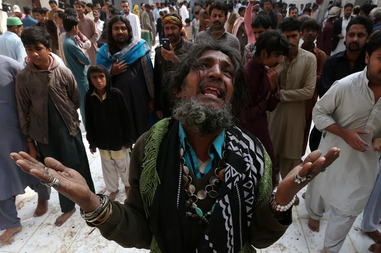 Homem chora por um parente morto em ataque a um templo sufi no Paquistão (Akhtar Soomro/Reuters)