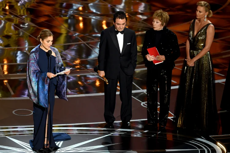 Anousheh Ansari e Firouz Naderi, cientistas da NASA, aceitam estatueta de melhor filme estrangeiro em nome de Asghar Farhadi (Kevin Winter/Getty Images)