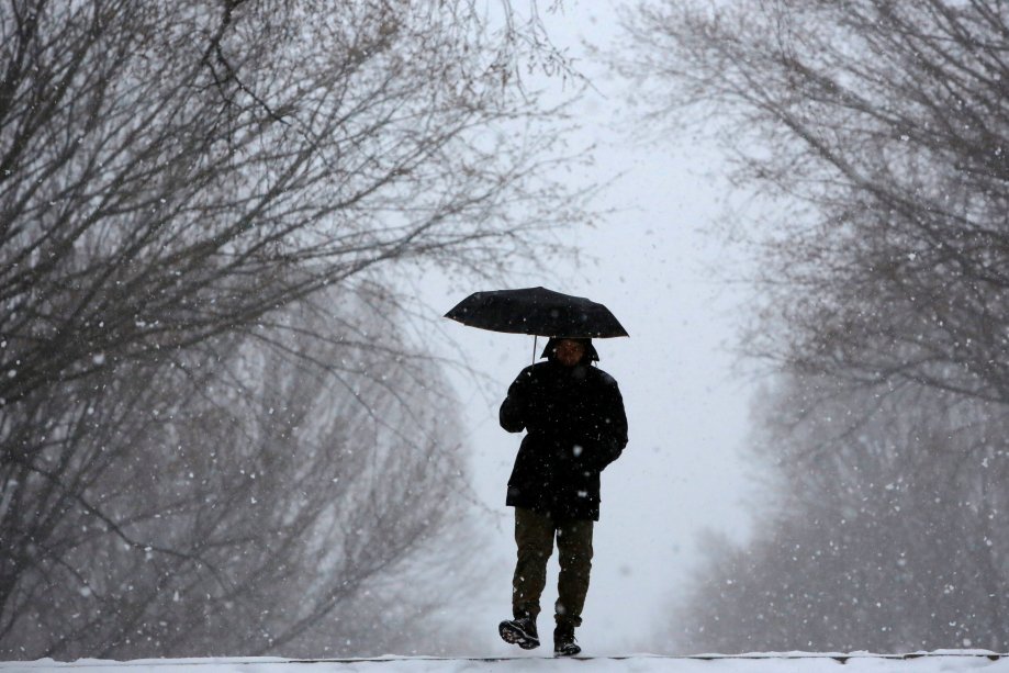 Homem caminha no Central Park durante nevasca em Nova York